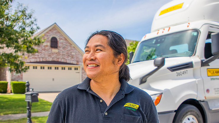 J.B. Hunt intermodal driver standing in front of truck in a neighborhood
