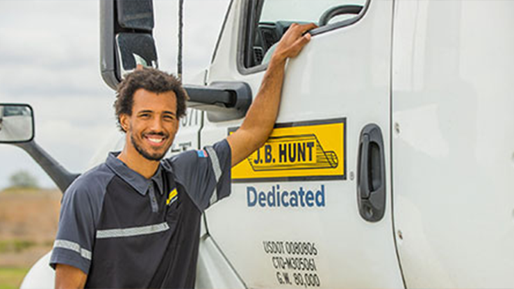 J.B. Hunt dedicated driver standing next to a truck