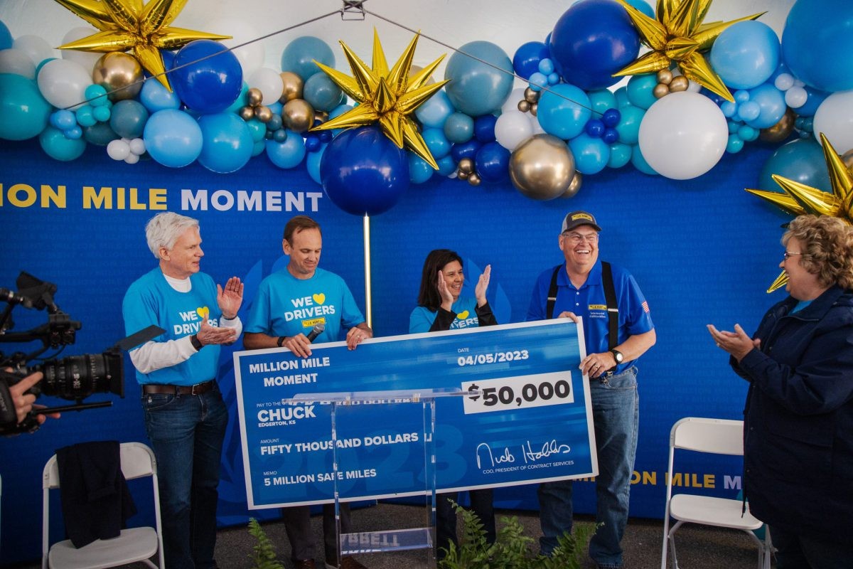 J.B. Hunt 5 million mile driver Chuck holds a giant check for $50,000.