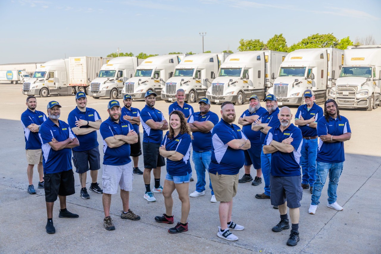 The 2024 Truck Driving Championship employee group representing J.B. Hunt standing in front of J.B. Hunt trucks.