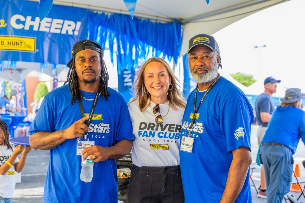J.B. Hunt drivers stand in a group and smile.