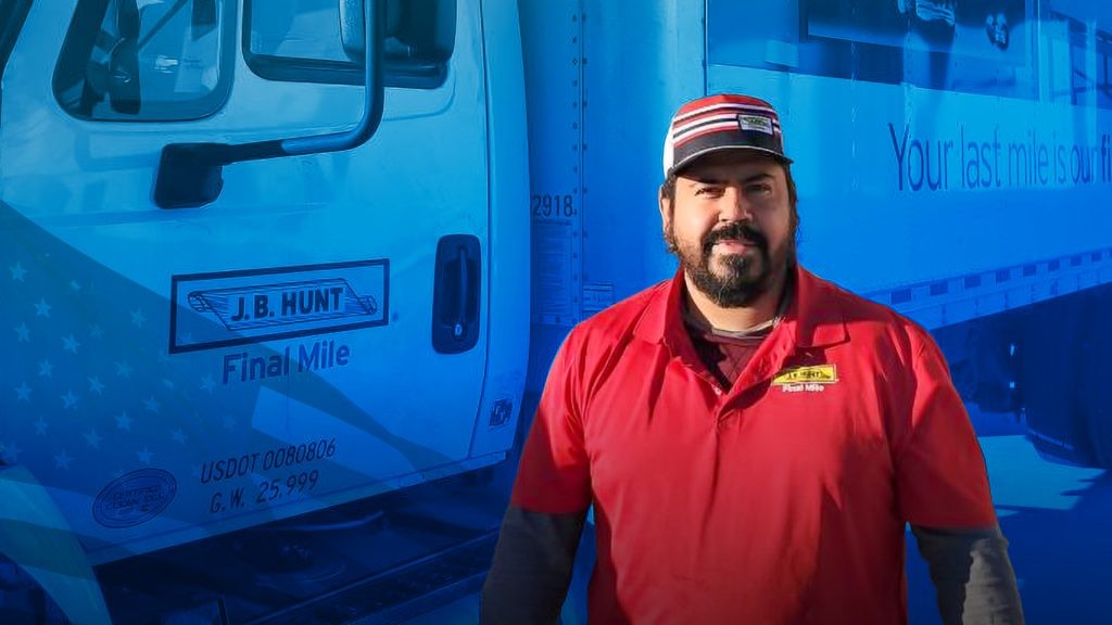 J.B. Hunt driver Jose stands in front of his Final Mile Services truck. Blue graphic overlay with American flag.