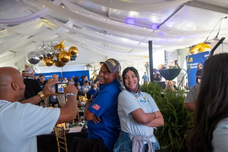 driver and family member pose together for picture in the million mile tent