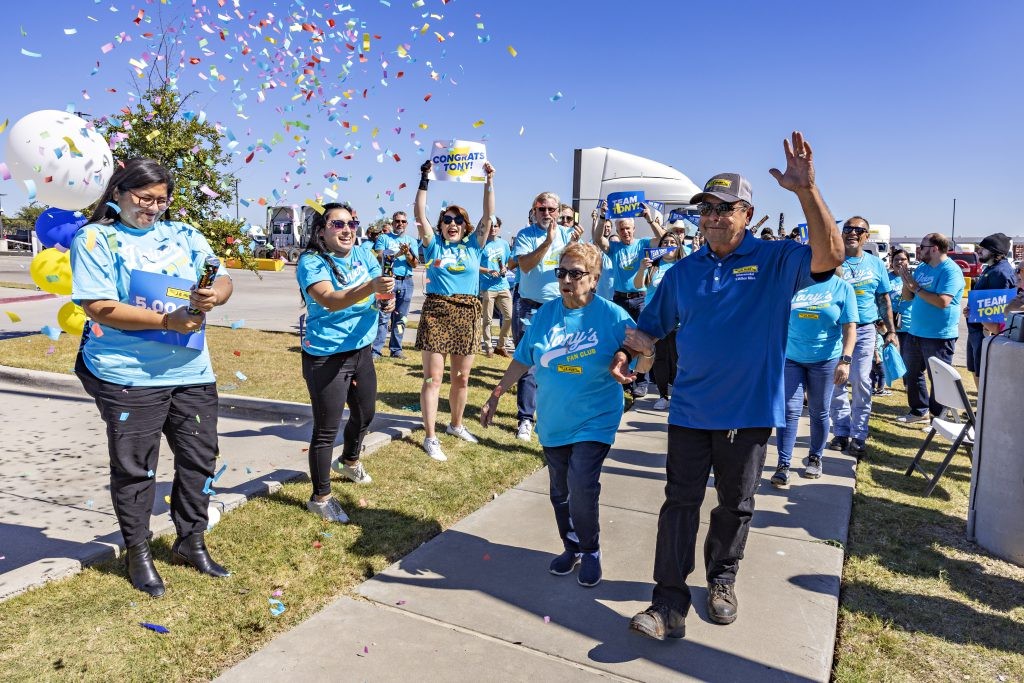 Tony, J.B. Hunt five million mile safe driver, walks through confetti and cheering people.