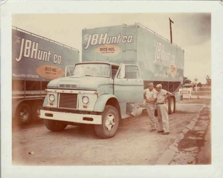 J.B. Hunt two J.B. Hunt drivers standing next to an older J.B. Hunt box truck.