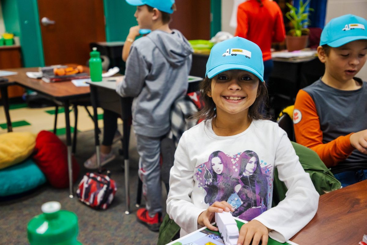 Child smiles wearing J.B. Hunt ballcap.