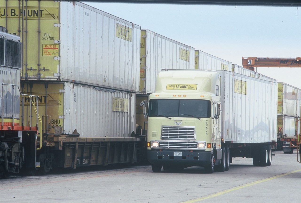 J.B. Hunt cabover truck next to intermodal containers.