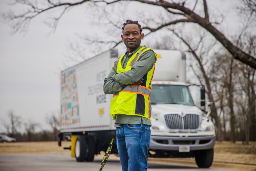 J.B. Hunt FMS driver stands in front of Final Mile Services box truck.
