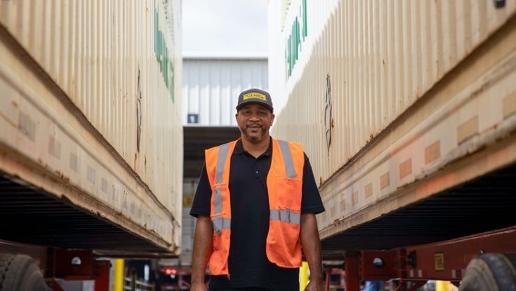 J.B. Hunt Intermodal driver, Roy, walking alongside J.B. Hunt shipping containers.