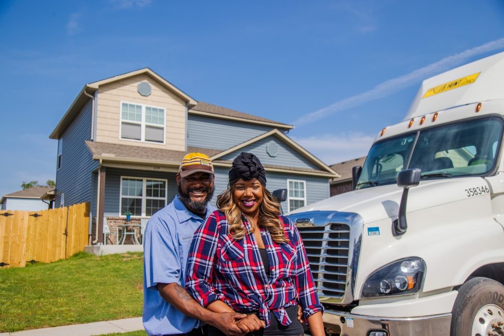 J.B. Hunt driver Derrick and his wife smile and stand next to his truck.