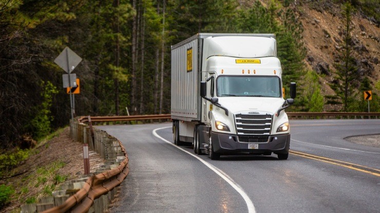 j.b. hunt truck driving down a rural forest road