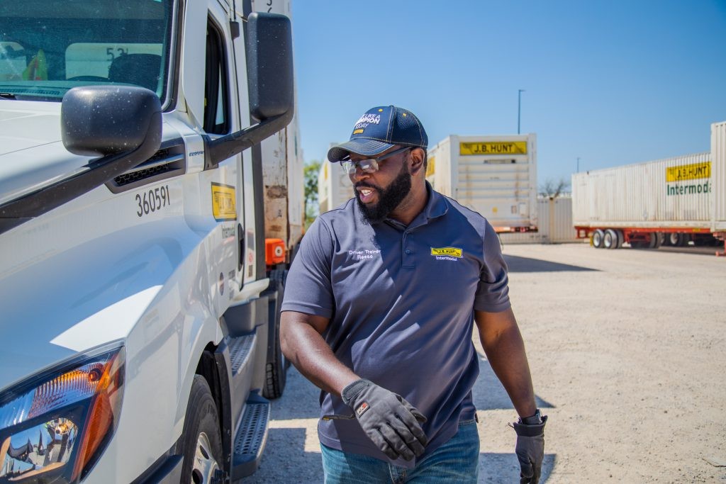 J.B. Hunt driver walks toward a day cab parked in an intermodal yard.