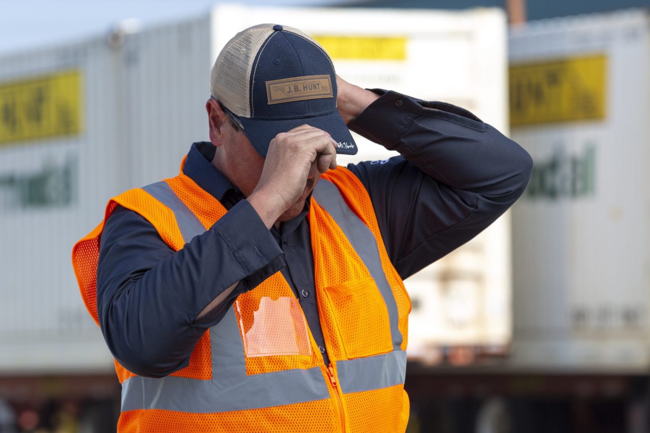 J.B. Hunt Driver adjusting J.B. Hunt trucker cap on head.
