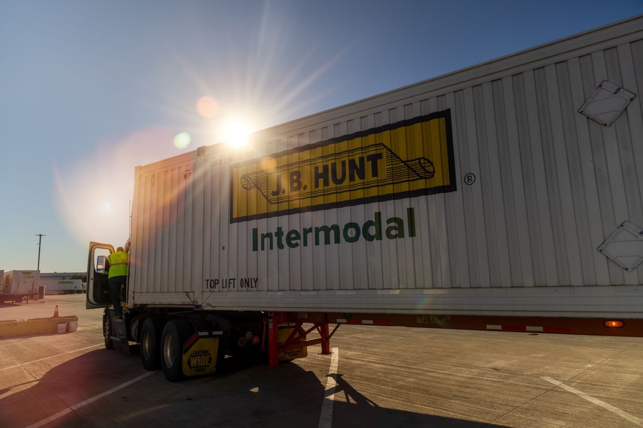 J.B. Hunt Intermodal container on a truck trailer at a freight yard, with sunlight shining behind the container.