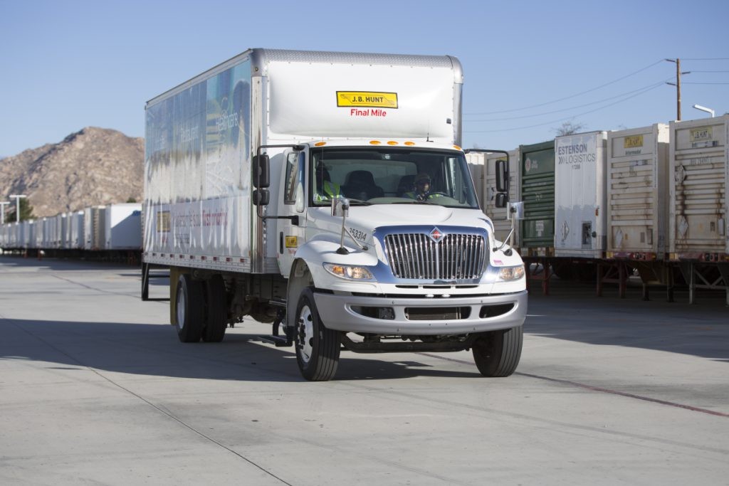 J.B. Hunt FMS box truck drives through a parking lot.