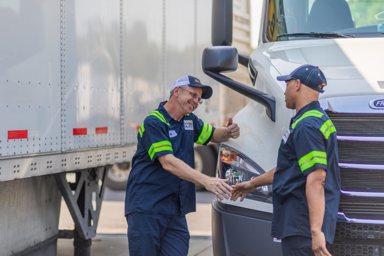 A driver shaking hands with their manager.