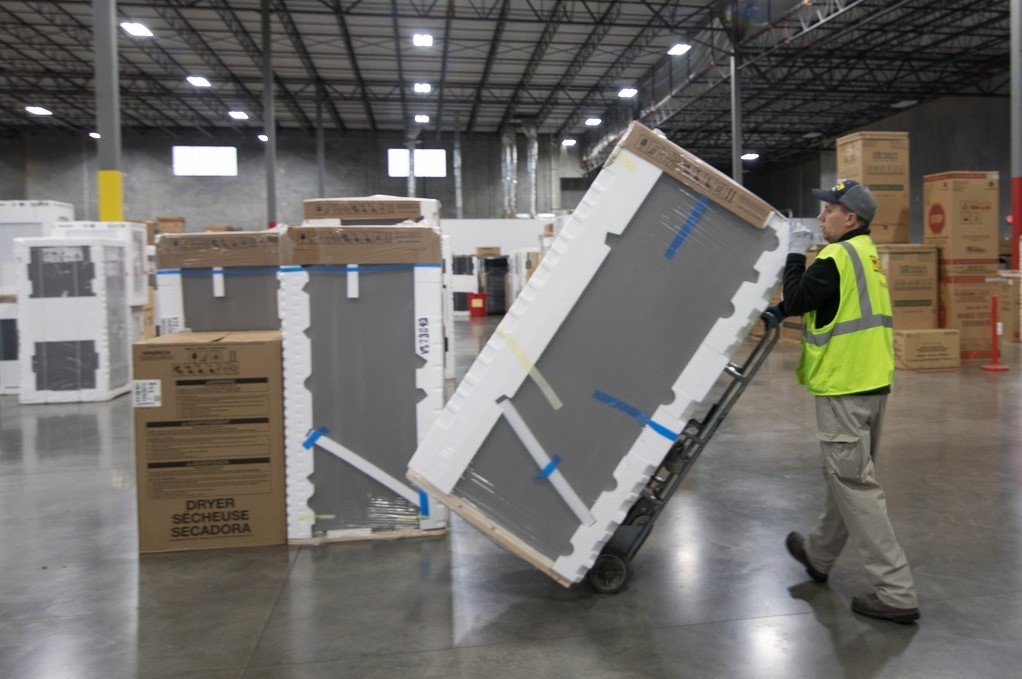 J.B. Hunt Final Mile Services driver John moving appliances in warehouse. 