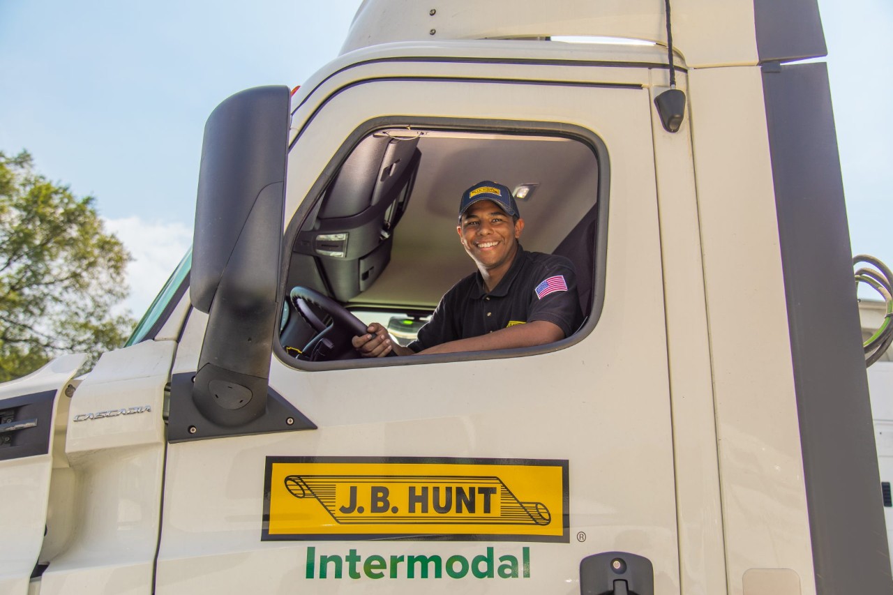J.B. Hunt driver, Robert, sitting in the driver seat of a J.B. Hunt Intermodal truck smiling at the camera.
