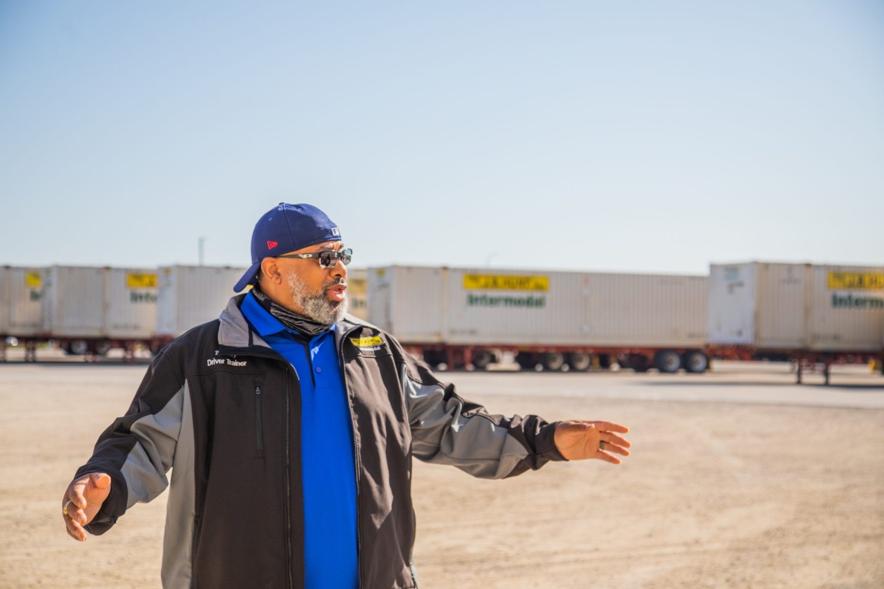 J.B. Hunt driver, Rodney, standing in an intermodal yard speaking to someone off camera.