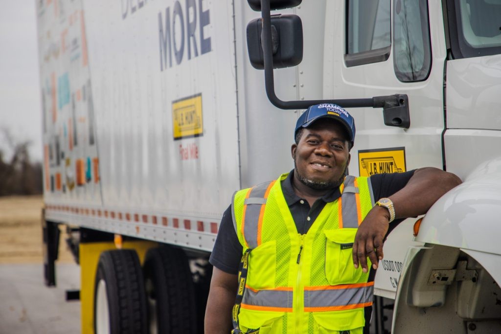 J.B. Hunt FMS driver leans on the cab of Final Mile Services box truck.