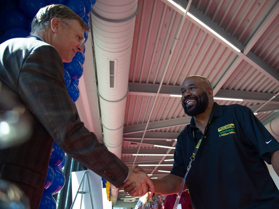 Intermodal driver with 2 million safe driving miles shakes hands with corporate employee. 