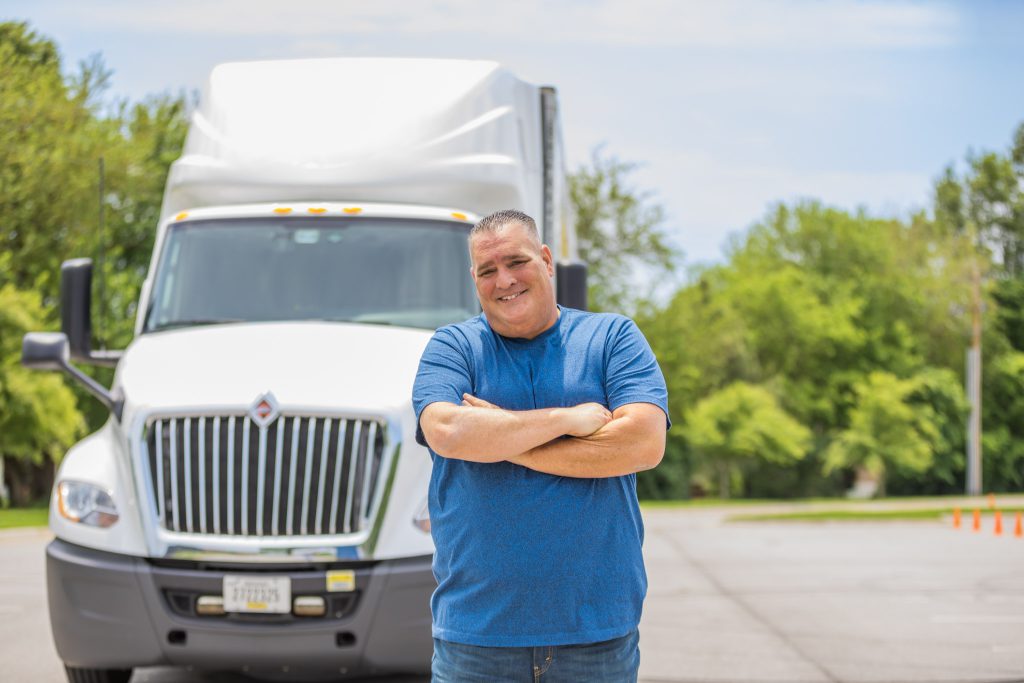 J.B. Hunt owner operator Jeff stands in front of his truck and smiles.