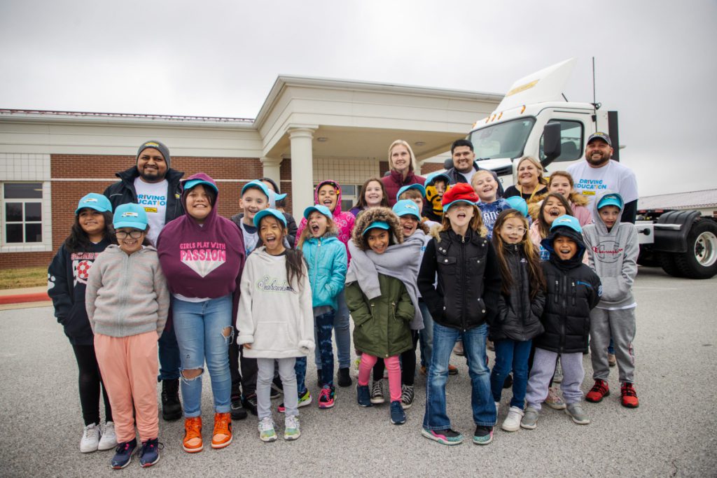 Adopt-A-Class classroom stands outside for group photo in front of school and J.B. Hunt day cab.
