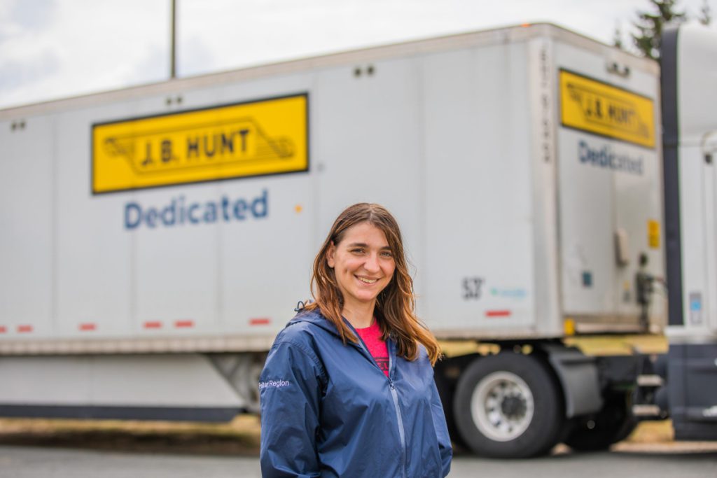J.B. Hunt driver Suzanne stands in front of a DCS® trailer and smiles.