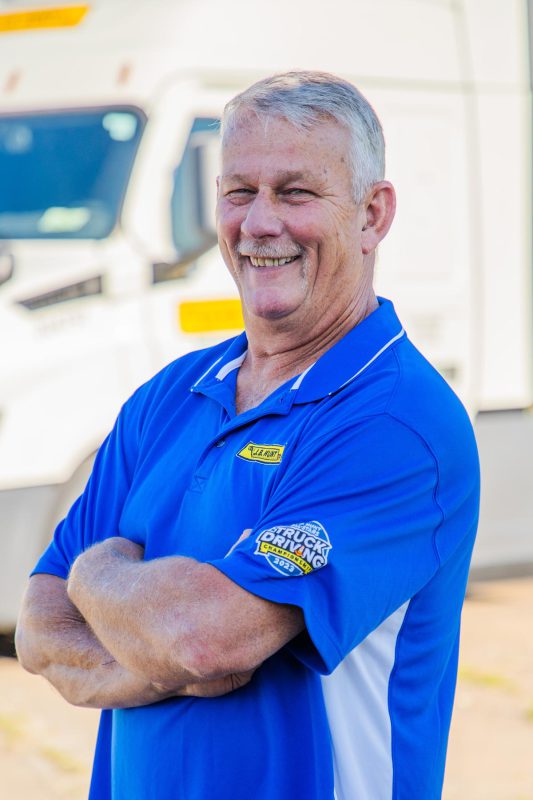 J.B. Hunt driver Darrell stands with arms crossed and smiles.