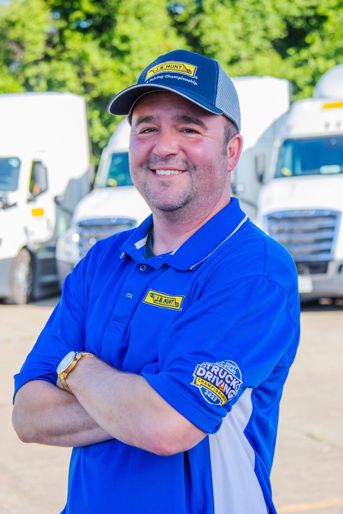 J.B. Hunt driver Phillip stands with arms crossed and smiles.