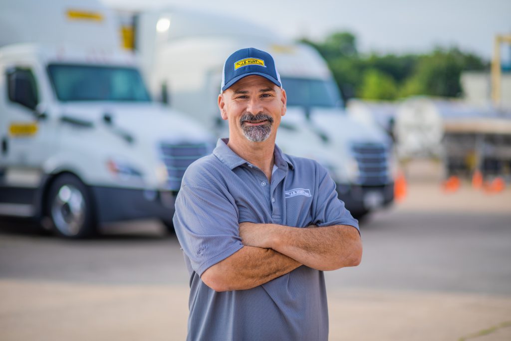 J.B. Hunt driver David stands with arms crossed and smiles.