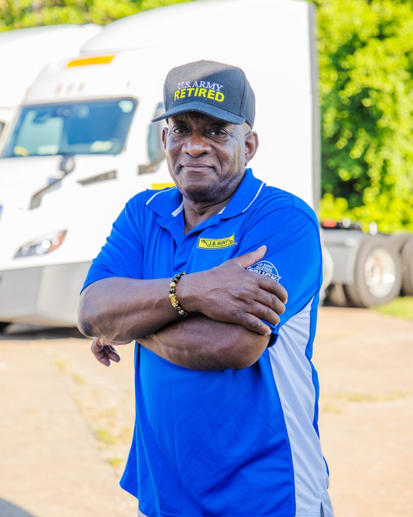 J.B. Hunt driver Louis stands with arms crossed and smiles.