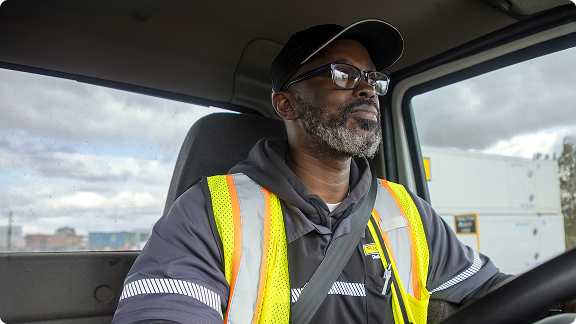 Driver in cab wearing high vis vest