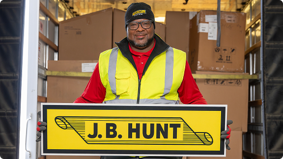 drive holding j.b. hunt sign in back of truck loaded with boxes
