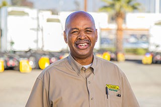 dedicated driver in front of j.B. Hunt trucks