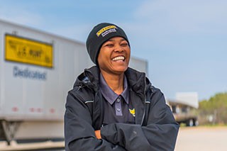 Dedicated truck driver standing beside dedicated trailer