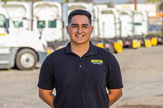 J.B. Hunt Intermodal driver in front of several parked trucks in a parking lot