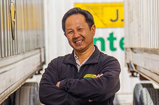 J.B. Hunt driver standing in between two trailers