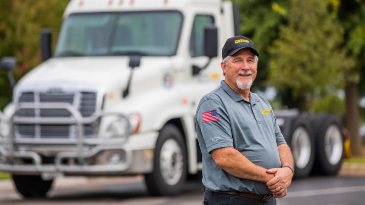 J.B. Hunt veteran driver standing in front of a parked truck