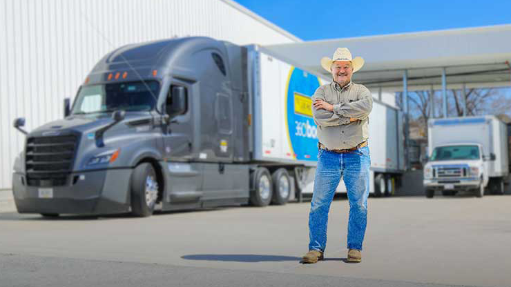Owner operator driver in front of a J.B. Hunt 360box truck